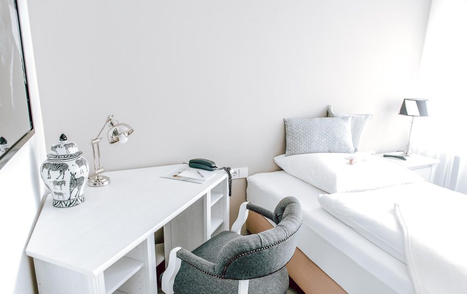 Boxspringbett und Arbeitsbereich im Standard Zimmer